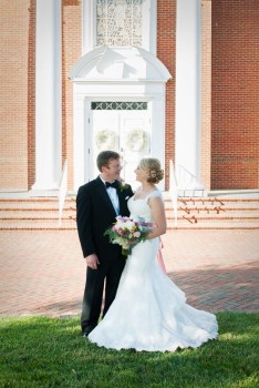 Newly married couple stands in front of church