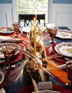 A wood box centerpiece with pumpkins,wheat, antlers, and acorns is the perfect fall centerpiece for your Thanksgiving table.
