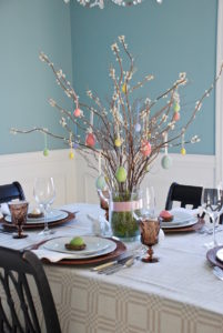 Set a sophisticated Easter table with pastel details and rustic elements.