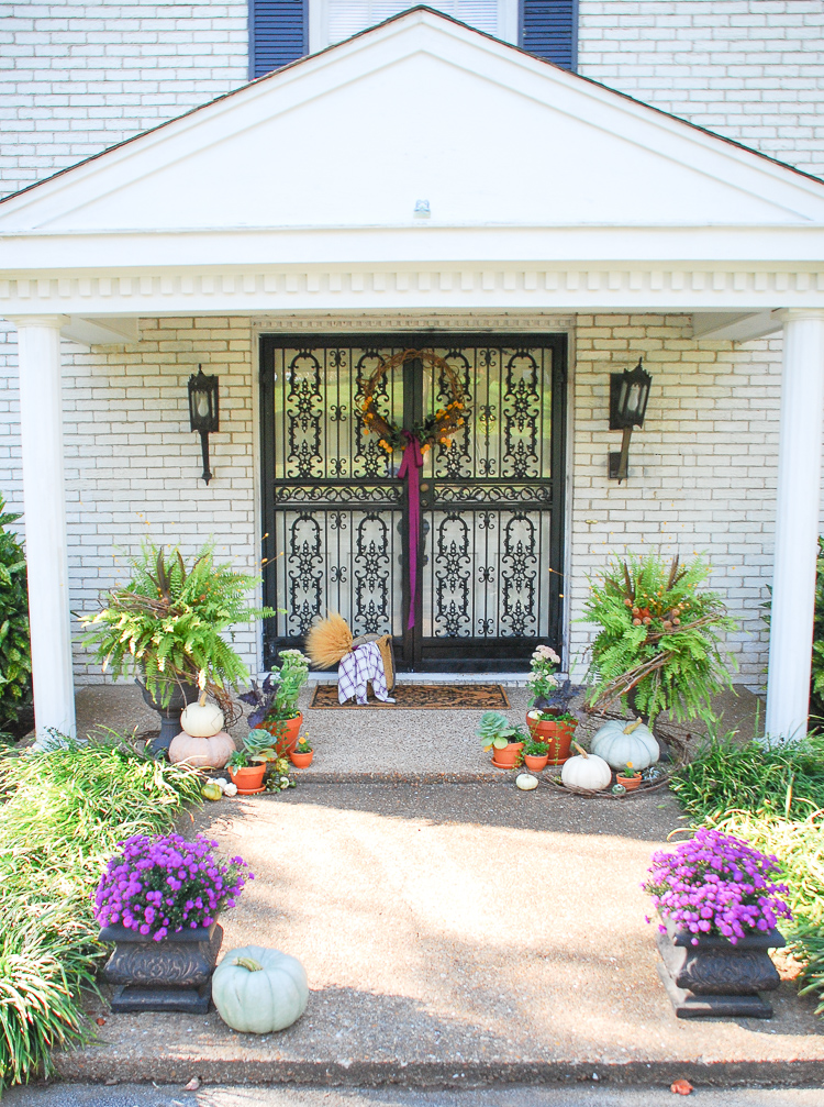 Elevate your curb appeal by adding autumn charm at the front door with punches of purple, heirloom pumpkins, terra cotta pots, fall plants, and festive ferns.