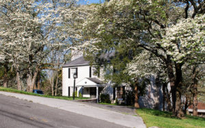 Naming your house: white brick house with dogwood trees in bloom