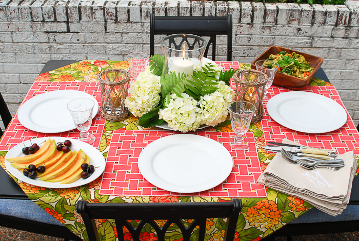 Table set for al fresco summer dining with hydrangea centerpiece and vibrant linens