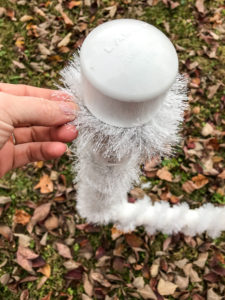 Close up of tinsel garland around PVC joy sign - easy DIY outdoor Christmas decoration