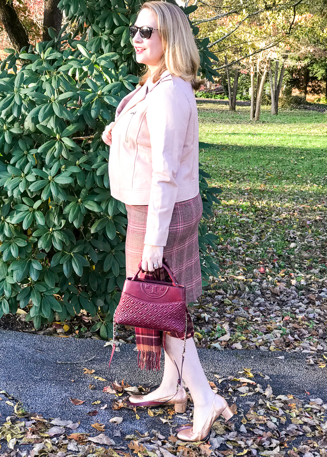 5 winter plaid pieces for work - blonde woman gazes in distance wearing pink moto jacket and plaid skirt
