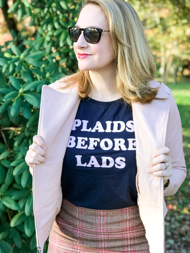 Blonde woman wearing graphic tee and pink moto jacket