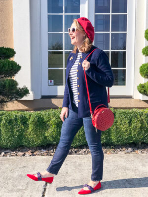 Woman wearing red beret and navy jacket with striped shirt and circle handbag for a red loves navy everyday chic look