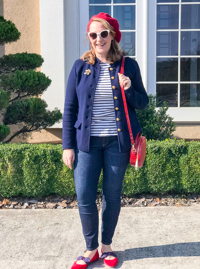 Woman wearing red beret and navy jacket with striped shirt and circle handbag for a red loves navy everyday chic look