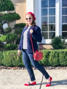 Woman wearing red beret and navy jacket with striped shirt and circle handbag for a red loves navy everyday chic look