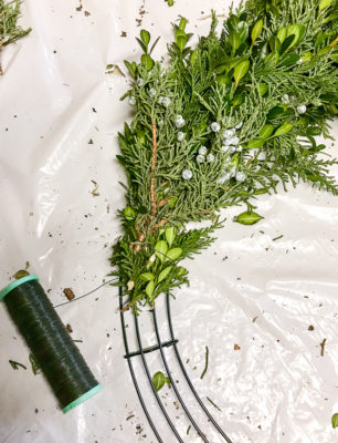 DIY Christmas wreath tutorial - securing greenery to frame by wrapping wire around stems