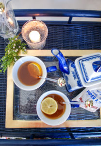 Overview of lemon berry hot toddy in blue and white porcelain on gold tray with jingle bell stirrers