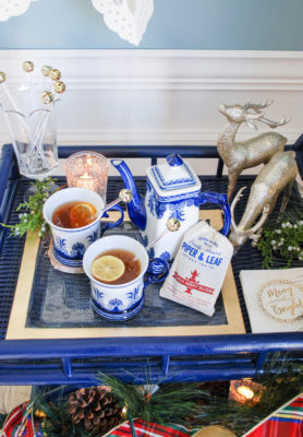 Lemon berry tea hot toddy in blue and white china on a blue rattan bar cart decorated for Christmas