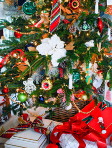 Pretty presents under a tree with wicker tree collar around this preppy & plaid Christmas tree