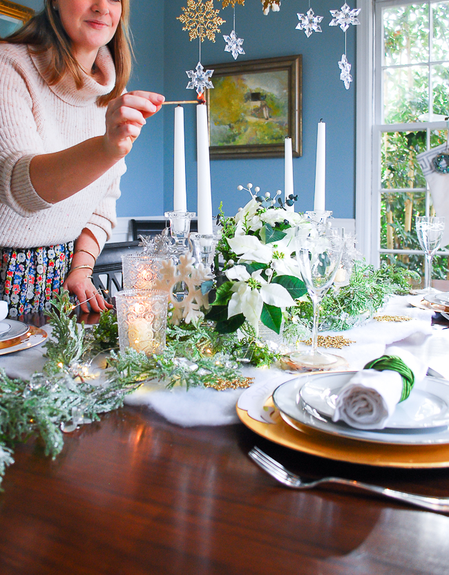 Winter tablescape tutorial - woman lights candles
