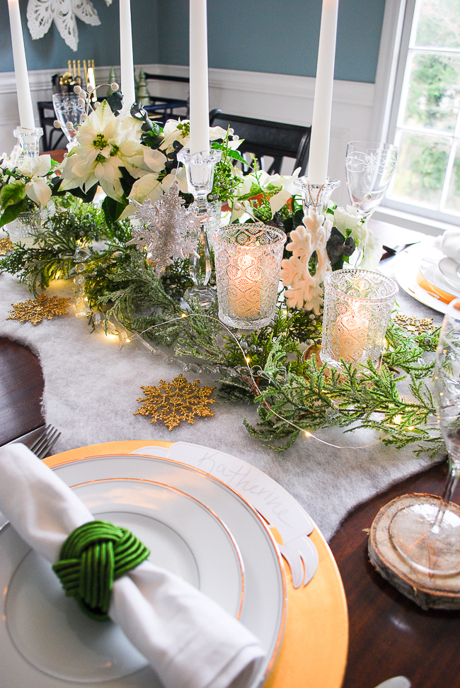 Winter tablescape tutorial for a frosted forest tablescape in green, gold, and white with poinsettia, snowflakes, birch, and cedar garland