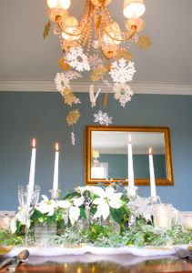 Winter tablescape tutorial for frosted forest table with snowflakes hung from chandelier