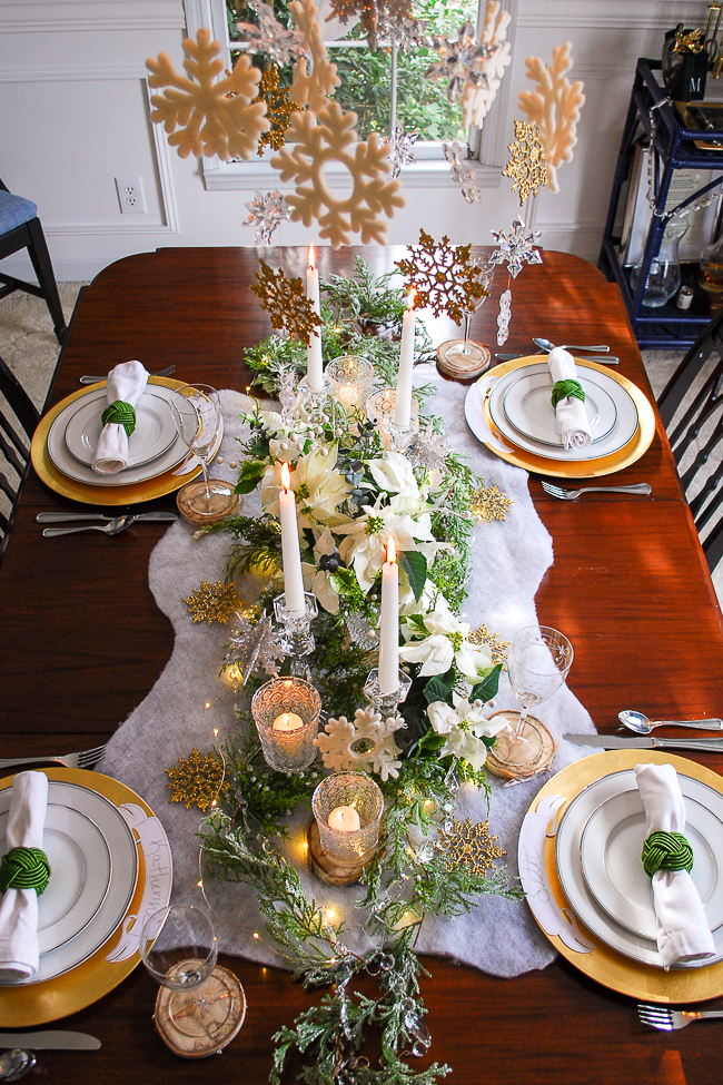 Winter tablescape tutorial for a frosted forest tablescape in green, gold, and white with poinsettia, snowflakes, birch, and cedar garland