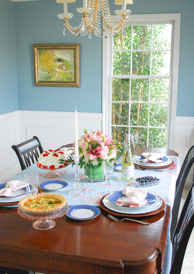A spring table setting in pink and blue to freshen up the dining room with romantic florals, blue lace china, and gingham napkins.