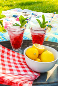 Blueberry lemon mint fizz drinks on a tray with lemons.
