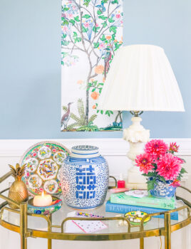 Affordable Chinoiserie decor on gold bar cart with fanciful landscape in background