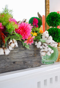 Fall dish garden in faux bois container centers fall mantel with majolica, magnolia, antlers, and cotton stems