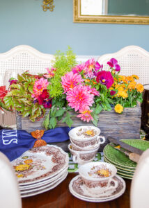 Fall dish garden with pink dahlias, mums, pansies, and fern on fall tablescape