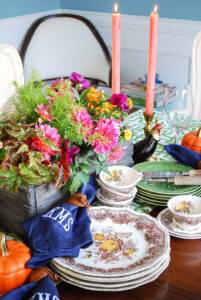 A Southern autumn table set with Mason's china, monogrammed napkins, fall florals, and trellis runner