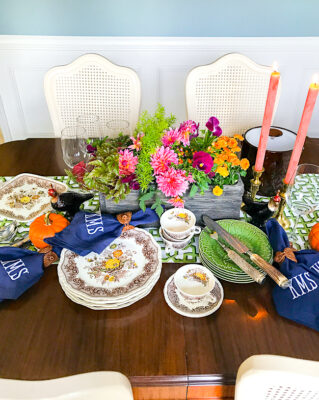 A Southern autumn table set with Mason's china, monogrammed napkins, fall florals, and trellis runner