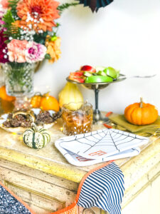 Eeeek plates, paper bats, and a flag garland decorate this Halloween treat bar filled with yummy desserts.