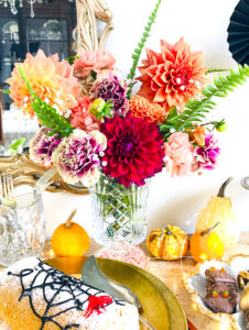 Orange, pink, and red dahlias and carnations add that floral touch to this Halloween dessert bar