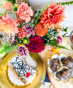 Orange, pink, and red dahlias and carnations add that floral touch to this Halloween dessert bar
