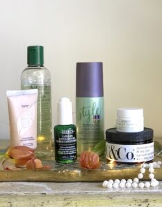 Group of fall beauty finds on Florentine tray with orange tulips and pearls