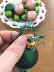 Loop thread through ornament eyelet to string on garland