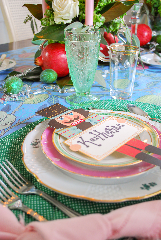 Whimsical place setting with pink and green china and paper nutcracker place cards