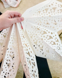 Cut apart paper snowflake to stick between tree branches