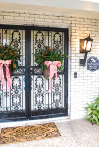 Katherine's front doors with baskets of pine and magnolia with pink bows