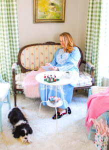 Katherine of Pender & Peony sitting on settee writing note in blue caftan