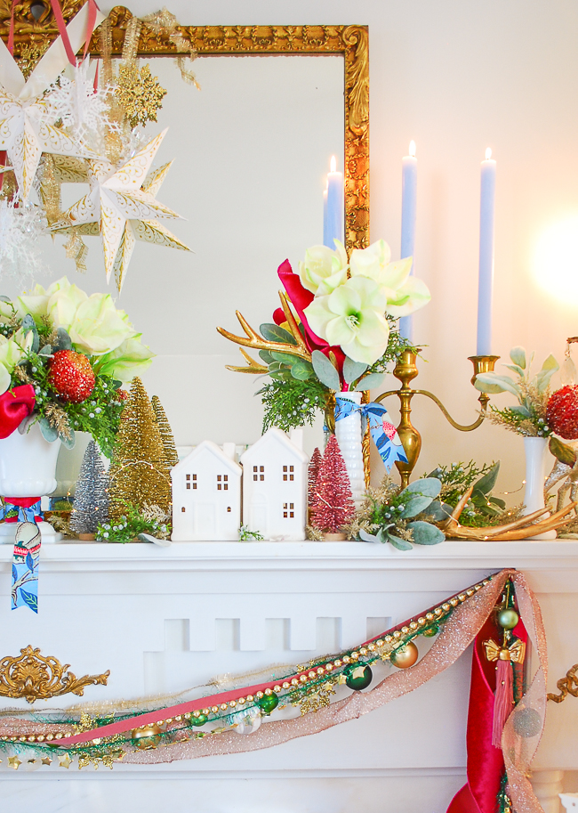 White ceramic houses on this Christmas mantel suggest a snowy winter village