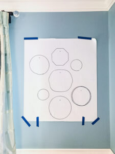 Tape paper layout template to wall
