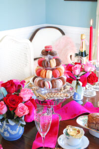 Pink, cream, brown, and orange colored macarons nestled on tower for Valentine's Day tea party