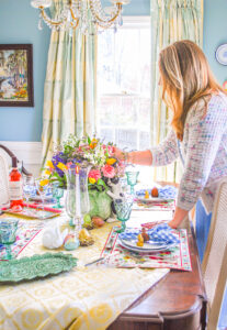 Katherine adjusts flowers in centerpiece on spring table