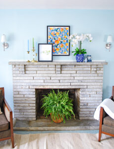 Asymmetrical arrangement for a preppy traditional mantel in blue and white with pops of orange and green