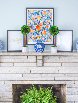 Another important elevated essential of this preppy traditional mantel is natural elements done here with boxwood topiaries and a fern.