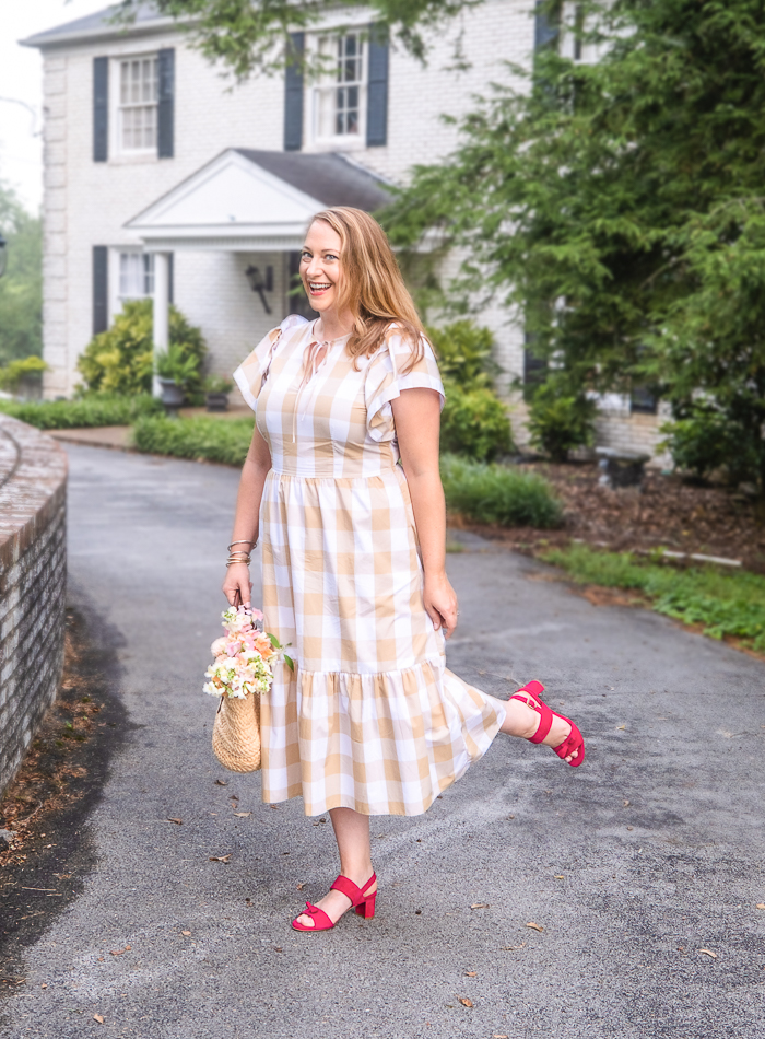 Katherine in gingham dress with straw handbag and sassy pink sandals from Sarah Flint