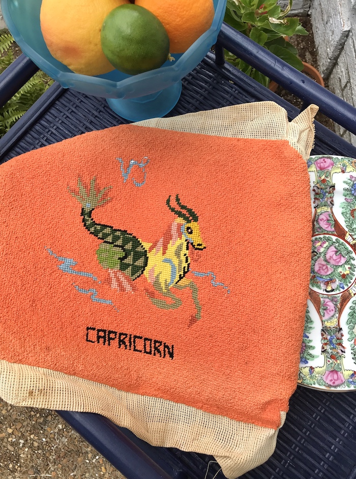 Vintage needlepoint Capricorn symbol with orange background