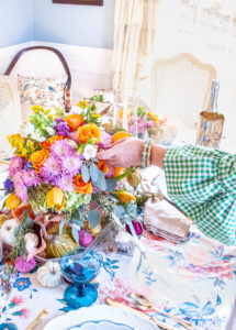 Katherine reaches out to fluff flower in autumn floral centerpiece