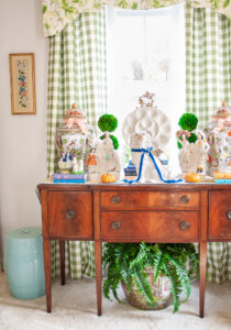 Sideboard decorated with Staffordshire figures, pumpkins, and ribbon