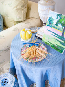 Bouquet of wheat tied with blue velvet ribbon laid on Rose Medallion plate