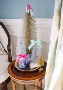 Bold and silver bottle brush trees with pink and green ribbon nestled in Wedgwood Jasperware vases