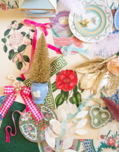 Georgian Chinoiserie Garden Christmas Decoration inspiration shown in flatlay, featuring camellia prints, Wedgwood, pink gingham, Rose Medallion, greek key trim, feathers, and velvet ribbon.