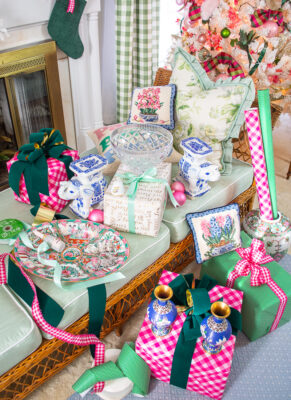 Selection of luxe gifts for the grandmillennial laid including Waterford crystal bowl, Rose Medallion platter, cloisonné vases, needlepoint pillows, and sterling silver